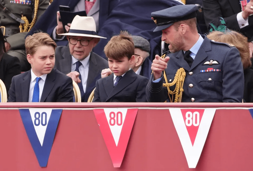 Prince William with two boys and an older man at an event with "80" pennants.