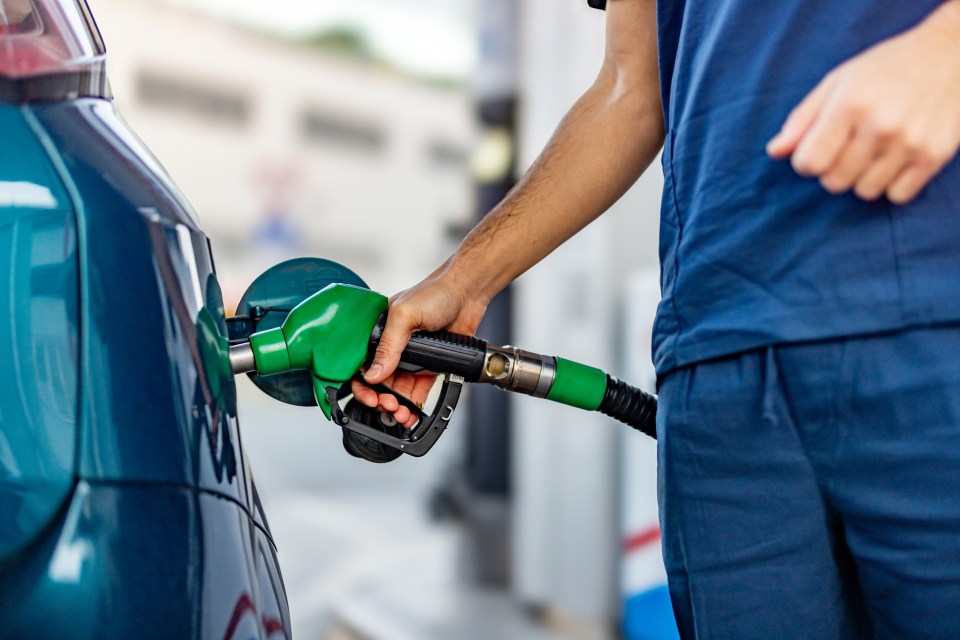Young man refuelling his modern car at petrol station