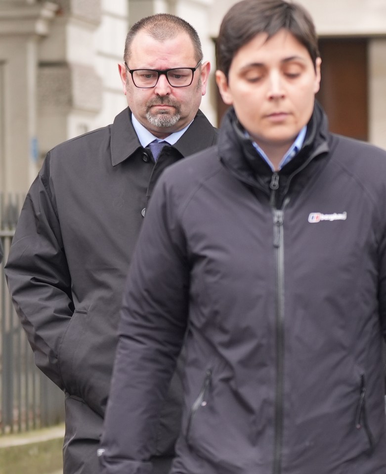 Two police officers leaving a courthouse.