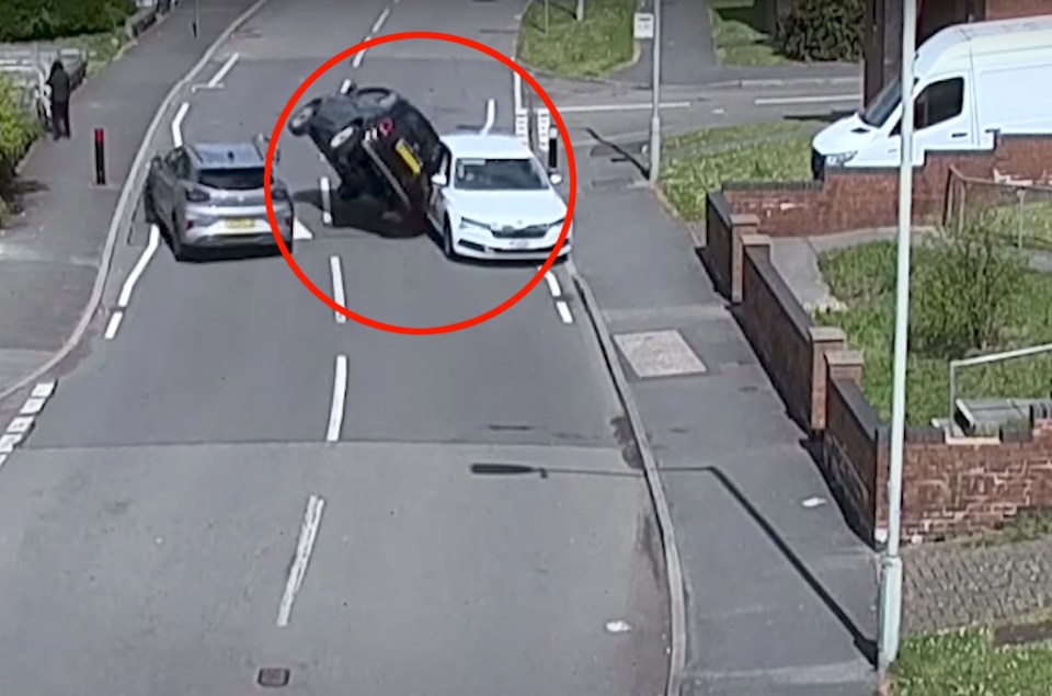 A car flipped on its side after colliding with another car.