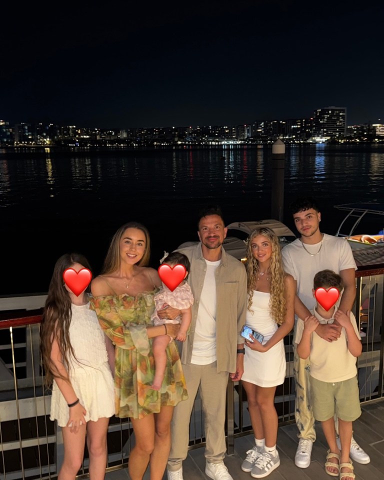 Family posing for a photo at night by the water.
